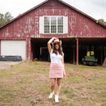 About how Corinne left Corporate pink hat and a barn